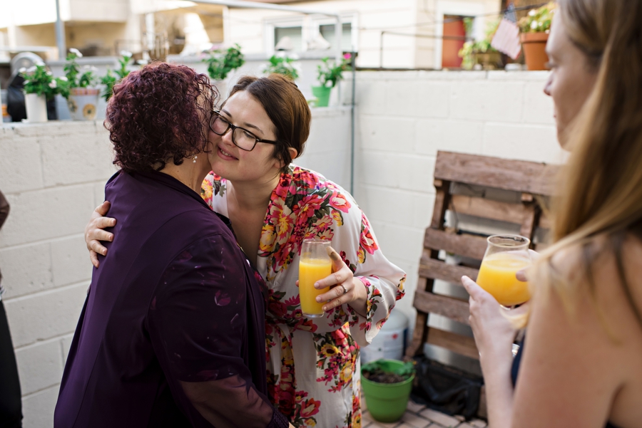 A bride hugs her mother in the backyard of her south Philly home.